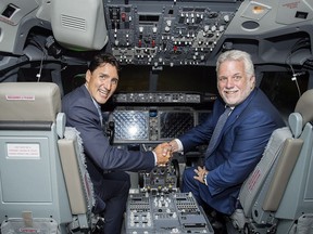 Prime Minister Justin Trudeau, left, and Quebec Premier Philippe Couillard sit in a flight simulator during a visit to CAE in Montreal, Wednesday, August 8, 2018.THE CANADIAN PRESS/Graham Hughes