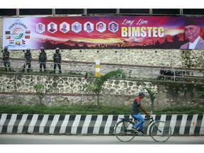 A man pedals past a street decorated ahead of the two-day summit of the Bay of Bengal Initiative for Multi-Sectoral Technical and Economic Cooperation (BIMSTEC) in Kathmandu, Nepal, Thursday, Aug. 30, 2018. Leaders of seven South Asian and Southeast Asian nations are meeting in Nepal to discuss regional trade, economic cooperation, security and peace.