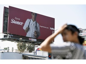 This May 9, 2018 photo shows a billboard for MedMen, a marijuana dispensary, at an intersection in Los Angeles. MedMen recently rolled out an ad campaign that featured photos of 17 people including a white-haired grandmother, a schoolteacher, a business executive, a former pro football player and a nurse, being splashed across billboards, buses and the web.