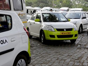 FILE - In this file photo dated March 29, 2016, Ola cabs wait for customers in Kolkata, India.  In a company announcement issued Tuesday Aug. 7, 2018, Indian ride-hailing service Ola said it plans to launch in the U.K., following its launch in Australia.