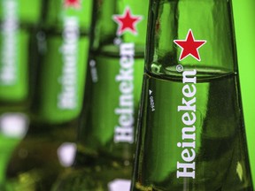 FILE - In this file photo dated Friday, March 30, 2018, bottles of Heineken beer are photographed in Washington, USA.  Dutch brewing company Heineken said in a statement Friday Aug, 3, 2018, it is buying a 40 percent stake in the company that controls China's biggest beer maker, China Resources Beer.