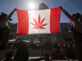 Two people hold a modified design of the Canadian flag during a "420 Toronto" rally in Toronto. Canada’s most populous province will be an important market for the burgeoning marijuana industry.
