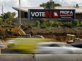 In this photo taken Wednesday, Aug. 1, 2018, motorists pass a sign against Proposition A in Kansas City, Mo. Missouri votes Tuesday, Aug. 7 on a so-called right-to-work law, a voter referendum seeking to ban compulsory union fees in all private-sector workplaces.