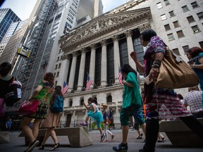 Pedestrians pass the in front of the New York Stock Exchange (NYSE) in New York.