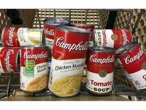 FILE - This May 23, 2017, file photo shows a variety of Campbell's soups in a grocery cart at a store in Phoenix. Campbell Soup Co. plans to focus on its core snacks and soup business in North America and sell its international business, paying down debt. The Camden, N.J., company said Thursday, Aug. 30, 2018, it's working urgently to complete all the moves by next July.