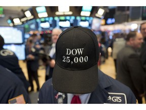 FILE- In this Jan. 4, 2018, file photo a stock trader wears a "Dow 25,000" hat at the New York Stock Exchange. If stocks don't drop significantly by the close of trading Wednesday, Aug. 22, the bull market that began in March 2009 will have lasted nine years, five months and 13 days, a record that few would have predicted when the market struggled to find its footing after a 50 percent plunge during the financial crisis.