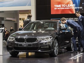 FILE- In this Jan. 13, 2017, file photo men look at a BMW 5 series during the media day of the 95th European Motor Show in Brussels. The Insurance Institute for Highway Safety, in a paper titled "Reality Check," issued the warning Tuesday, Aug. 7, 2018, after testing five of the systems from Tesla, Mercedes, BMW and Volvo on a track and public roads. The systems tested, in the Tesla Model 3 and Model S, BMW's 5-Series, the Volvo S-90 and the Mercedes E-Class, are among the best in the business right now and have been rated "superior" in previous IIHS tests. David Zuby, the institute's chief research officer, said the systems do increase safety but the tests show they are not 100 percent reliable.