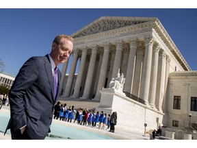 FILE- In this Feb. 27, 2018, file photo Microsoft President and Chief Legal Officer Brad Smith, left, leaves the Supreme Court in Washington. Microsoft stands virtually alone among tech companies with its aggressive approach that uses U.S. courts to fight computer fraud and seize hacked websites back from malicious perpetrators. "What we're seeing in the last couple of months appears to be an uptick in activity," said Smith.