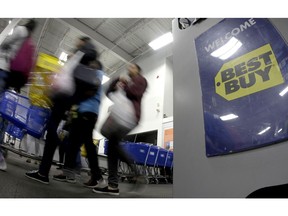 FILE- In this Nov. 23, 2017, file photo people enter a Best Buy store as it opened for a Black Friday sale on Thanksgiving Day in Overland Park, Kan. Best Buy reports financial results on Tuesday, Aug. 28, 2018.