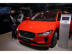 FILE- In this April 25, 2018, file photo journalists and visitors look at the Jaguar electric-powered I-Pace model showcases at the China Auto Show during the media day in Beijing. While Tesla grapples with internal issues like production delays, a sometimes-erratic CEO and a recent about-face on whether to go private, its rivals are moving aggressively into the luxury electric vehicle space. Jaguar Land Rover has the I-Pace.