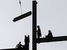 FILE- In this June 1, 2018, photo ironworkers construct a commercial and residential building in Philadelphia. On Wednesday, Aug. 15, the Commerce Department reported that U.S. productivity grew at an annual rate of 2.9 percent in the second quarter, the fastest pace in more than three years, while labor costs actually fell.