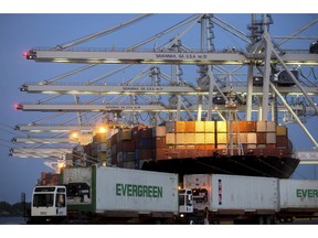In this June 19, 2018 photo, several ship to shore cranes stack shipping containers on-board the container ship Maersk Semarang while three Ever Green Line refrigerated containers wait to be loaded onto another ship at the Port of Savannah in Savannah, Ga. On Wednesday, Aug. 29, the Commerce Department issues the second of three estimates of how the U.S. economy performed in the April-June quarter.