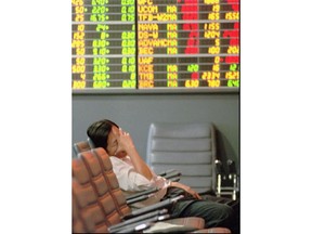 FILE- In this Nov. 21, 1997, file photo a Thai stock investor falls asleep while lonely monitoring a trading board at a stock house in the Stock Exchange of Thailand in Bangkok. A financial crisis that began in 1997 after Thailand devalued its currency against the U.S. dollar eventually sent markets reeling across the region in what became known as the Asian financial crisis.