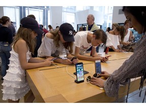 FILE- In this Aug. 2, 2018, file photo customers browse in an Apple store in New York. On Thursday, Aug. 30, the Commerce Department issues its July report on consumer spending, which accounts for roughly 70 percent of U.S. economic activity.