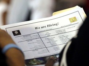 FILE In this June 21, 2018 file photo, a job applicant looks at job listings for the Riverside Hotel at a job fair hosted by Job News South Florida, in Sunrise, Fla.    Economists forecast that employers added 191,000 jobs in July, down from 213,000 in June but easily enough to lower the unemployment rate over time. The jobless rate is projected to decline to 3.9 percent, near an 18-year low, from 4 percent. The Labor Department's monthly jobs report will be released at 8:30 a.m. Eastern Friday, Aug. 3.