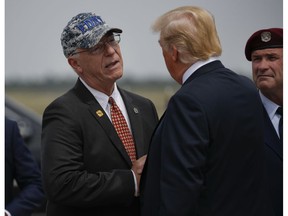 President Donald Trump, right, is greeted by John Raguso, left, a Gold Star Father, on the tarmac up his arrival at Francis S. Gabreski Airport in Westhampton, NY., Friday, Aug. 17, 2018. Raguso's son, Christopher Raguso, was a member of the New York Air National Guard who died in a helicopter crash in western Iraq in March 2018. Christopher Raguso served as a flight engineer and was a veteran of the New York City Fire Dept.