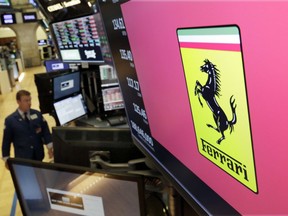 The logo for Ferrari is displayed above a trading post on the floor of the New York Stock Exchange, Wednesday, Aug. 1, 2018. Sports carmaker Ferrari confirms its 2018 earnings forecasts after posting an 18-percent rise in second-quarter profits and a rise in deliveries.