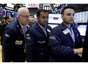 Trader Thomas Ferrigno, left, works with specialists Dilip Patel, center, and Karan Virdi on the floor of the New York Stock Exchange, Friday, Aug. 31, 2018. Stocks are opening mostly lower on Wall Street, led by declines in banks and energy companies.