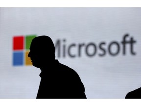 FILE - In this Nov. 7, 2017, file photo, a man is silhouetted as he walks in front of Microsoft logo at an event in New Delhi, India. Microsoft says it's uncovered new Russian hacking attempts targeting U.S. political groups ahead of the midterm elections. The company said Tuesday, Aug. 21, 2018, that a hacking group tied to the Russian government created fake internet domains that appeared to spoof two conservative organizations: the Hudson Institute and the International Republican Institute.