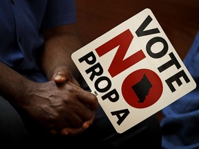 FILE - In this Tuesday, July 31, 2018, file photo, people opposing Proposition A listen to a speaker during a rally in Kansas City, Mo. Missouri votes Tuesday, Aug. 7 on a so-called right-to-work law, a voter referendum seeking to ban compulsory union fees in all private-sector workplaces.