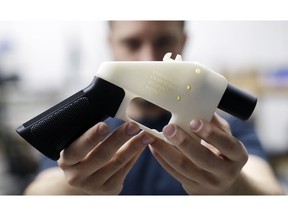 FILE - In this Aug. 1, 2018, file photo, Cody Wilson, with Defense Distributed, holds a 3D-printed gun called the Liberator at his shop in Austin, Texas. A federal judge in Seattle has granted an injunction that prohibits the Trump administration from allowing a Texas company to post 3D gun-making plans online.