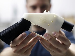 FILE--In this Aug. 1, 2018, file photo, Cody Wilson, with Defense Distributed, holds a 3D-printed gun called the Liberator at his shop in Austin, Texas. Eleven states have joined eight others and the District of Columbia in a federal lawsuit that seeks to block a settlement the Trump administration reached with a company that wants to post online plans to make 3D firearms on a printer.