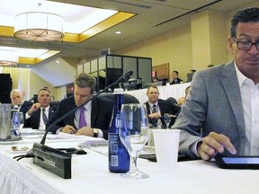 From left at table, Massachusetts Gov. Charlie Baker (partially obscured), Quebec Premier Philippe Couillard, Vermont Gov. Phil Scott, New Brunswick Premier Brian Gallant and Connecticut Gov. Dannel P Malloy attend the Conference of New England Governors and Eastern Canadian Premiers on Monday, Aug. 13, 2018, in Stowe, Vt.