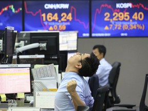 A currency trader stretches himself while working at the foreign exchange dealing room of the KEB Hana Bank headquarters in Seoul, South Korea, Monday, Aug. 6, 2018. Asian stocks rose Monday despite a new Chinese threat of tariff hikes on U.S. goods after Washington reported solid employment numbers.