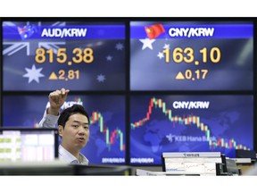 A currency trader gestures at the foreign exchange dealing room of the KEB Hana Bank headquarters in Seoul, South Korea, Friday, Aug. 24, 2018. Asian shares were Friday following a listless session on Wall Street, where a slide in banks and industrial companies offset solid gains for the technology sector. A lack of progress in trade talks between the U.S. and China was weighing on sentiment.