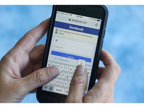 CORRECTING DATE OF ANNOUNCEMENT TO WEDNESDAY - FILE - In this file photo dated Tuesday, Aug. 21, 2018, a Facebook start page is shown on a smartphone in Surfside, Fla. USA.  The social media giant Facebook said late Wednesday Aug. 22, 2018, it has banned a quiz app for refusing to be audited and concerns that data on as many as 4 million users was misused, after it found user information was shared with researchers and companies.