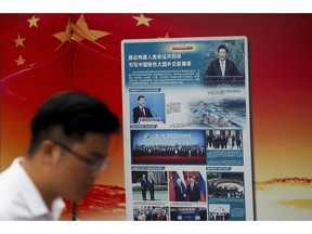 A man walks by a government propaganda billboard promoting Chinese President Xi Jinping's signature "One Belt One Road" outside a subway station in Beijing, Tuesday, Aug. 28, 2018. Chinese officials on Monday defended Beijing's initiative to build a "New Silk Road" of railways and other infrastructure across Asia against complaints it leaves host countries with too much debt after Malaysia canceled two high-profile projects. The officials said President Xi Jinping's signature foreign policy initiative is creating assets that are needed by developing countries but might take time to pay off.
