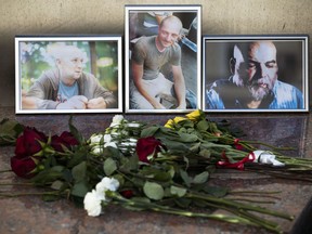 Flowers are placed by portraits of slain journalists Alexander Rastorguyev, Kirill Radchenko and Orkhan Dzhemal, at the Russian journalists Union building in Moscow, Russia, Wednesday, Aug. 1, 2018.  Russian journalists who were killed in the Central African Republic had been working on an investigation into Russian private military contractors and the mining industries there, their editor said Wednesday.