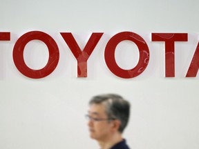 A visitor walks through a Toyota showroom in Tokyo Friday, Aug. 3, 2018. Toyota Motor Corp. has reported its quarterly profit climbed 7.2 percent, helped by strong sales in the U.S. and other overseas markets.