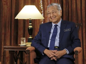 Malaysia's Prime Minister Mahathir Mohamad is interviewed in Putrajaya, Malaysia, Monday, Aug. 13, 2018. Mahathir said he will seek to cancel multibillion-dollar Chinese-backed infrastructure projects that were signed by his predecessor as his government works to dig itself out of debt, and he blasted Myanmar's treatment of its Rohingya minority as "grossly unjust."