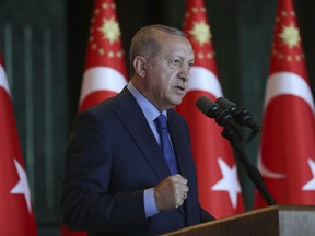 Turkey's President Recep Tayyip Erdogan, gestures as he delivers a speech to Turkish ambassadors at the Presidential Palace in Turkey, Monday, Aug. 13, 2018. Erdogan says his country is under an economic "siege" that has nothing to do with its economic indicators. He insisted that Turkey's economic dynamic remain strong and said the Turkish currency would soon settle "at the most reasonable level." (Pool Photo via AP)