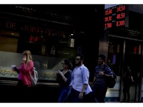 People walk by an exchange office in Buenos Aires, Argentina, Wednesday, Aug. 29, 2018.The Argentine currency fell again to an all-time low of 34,5 pesos for every U.S. dollar.President Mauricio Macri has asked the International Monetary fund for an early release of funds from a $50 billion deal with the IMF to ease concerns that Argentina will not be able to meet its debt obligations for 2019.