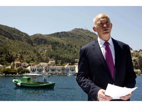 In this Friday, April 23, 2010 file photo Greek Prime Minister George Papandreou announces Greece's decision to request activation of a joint eurozone-International Monetary Fund financial rescue plan, from the main port of the remote southeast Greek Aegean island of Kastellorizo. From tiny Aegean island of Kastellorizo, Papandreou asked for a rescue package from Greece's eurozone partners and the International Monetary Fund.
