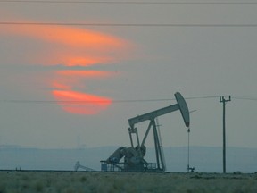 The sun sets behind an oil derek.