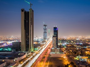 Light trails from traffic illuminate highways surrounded by residential buildings in Riyadh, Saudi Arabia.