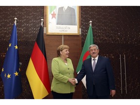 German Chancellor Angela Merkel shakes hands with Algerian Prime Minister Ahmed Ouyahia ahead of talks in Algiers, Monday Sept.17, 2018. Merkel is visiting Algeria for a day to promote bilateral ties and discuss migration and the situation in neighboring Libya.