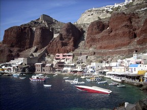 FILE  - In this Sept. 21, 2009 file photo, boats are seen on Ammoudi Bay near seaside tavernas on the island of Santorini, Greece. Tax authorities say they have used surveillance drones in Greece for the first time to spot violations on Santorini, where tourists were allegedly being taken on boat tours of the island's sea-filled volcanic crater without getting receipts. Greece's Independent Authority for Public Revenue says that the one-day operation last week involved surveillance of nine tour boats, and that the violations recorded in a follow-up inspection were worth 25,000 euros ($29,400) in lost revenue.