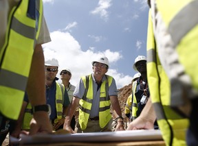 Mark Bristow, chief executive officer of Randgold Resources Ltd., center, listens to a briefing by members of his mining team in the open pit at the Kibali gold mine in Kibali, Democratic Republic of Congo in 2014.