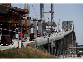 In this July 2, 2018, photo, traffic moves on the old Gerald Desmond Bridge next to its replacement bridge under construction in Long Beach, Calif. The new Gerald Desmond Bridge stretching over the Port of Long Beach is being built with about 75 seismic sensors called accelerometers. They'll measure the forces imparted on the bridge during an earthquake. It's slated to open next year.