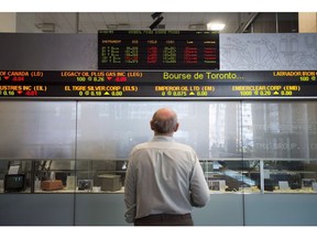 Canada's main stock index edged lower in late-morning trading as the industrials, financial and telecom sectors traded lower. A man watches the financial numbers on the digital ticker tape at the TMX Group in Toronto's financial district on Friday, May 9, 2014.