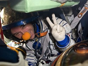 Space tourist Canadian billionaire and clown Guy Laliberte shows A victory sign while sitting inside the Soyuz TMA-14 spacecraft shortly after his landing with the members of the main mission to the International space station, Russian cosmonaut Gennady Padalka and NASA astronaut Michael Barratt, not seen, near the town of Arkalyk, Kazakhstan, on Sunday, Oct. 11, 2009. The federal tax court says the out-of-this-world trip taken by Quebec billionaire Guy Laliberte in 2009 is taxable.