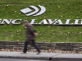 A man walks past the headquarters of SNC-Lavalin in Montreal on November 6, 2014. The preliminary inquiry into SNC-Lavalin Group Inc. has been shortened and pushed back six weeks, rescheduled to begin after a Criminal Code provision that its lawyer says will work in its favour comes into force.