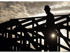 A construction worker climbs onto a roof at sunrise to avoid the heat, Tuesday, June 20, 2017 in Phoenix. Construction industry experts are scratching their heads over how Statistics Canada concluded that the sector lost 8,800 jobs last month because they says they're facing a wealth of openings and a lack of workers to fill them.