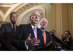 Senate Majority Leader Mitch McConnell, R-Ky., flanked by Sen. John Thune, R-S.D., left, and Majority Whip John Cornyn, R-Texas, speaks with reporters following their weekly policy meetings, at the Capitol in Washington, Tuesday, Sept. 18, 2018.