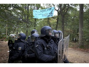 Police officers stand in the Hambach forest near Kerpen, western Germany, Thursday, Sept. 13, 2018.  which is occupied by protestors to stop from being chopped down for a lignite strip mine.