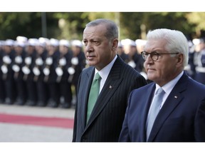 Turkish President Recep Tayyip Erdogan and German President Frank-Walter Steinmeier, right, review the honor guard during a military welcoming ceremony at the presidential palace in Berlin, Germany, Friday, Sept. 28, 2018. Erdogan is on a three-day official state visit to Germany.